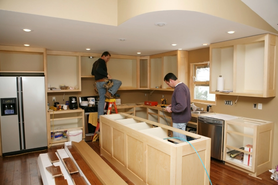 workers installing some cabinets on a remodeled kitchen
